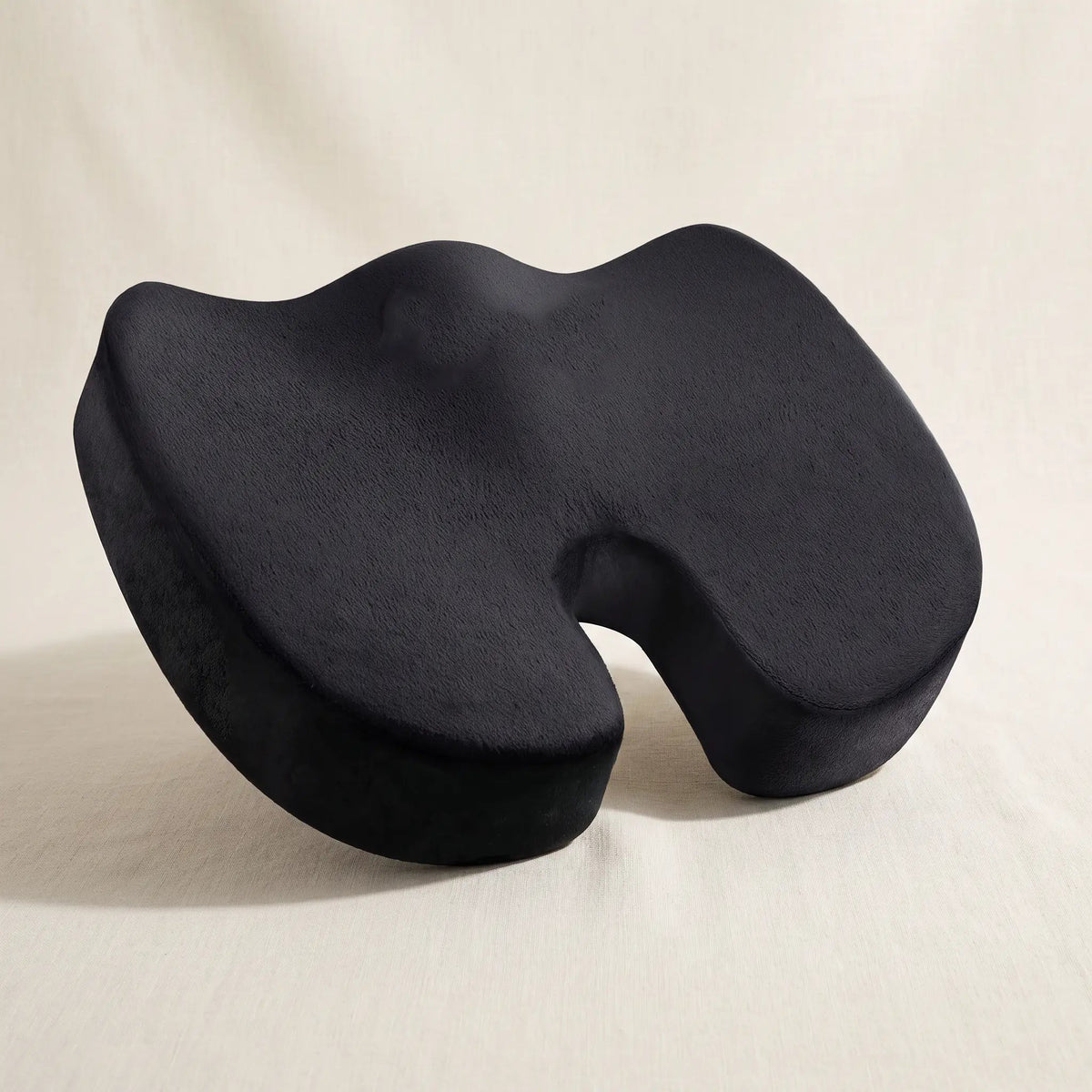 The Vertovia coccyx seat cushion, three-quarter view on a linen surface